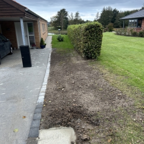 Kantafgrænsning langs hæk som forberedelse til belægning ved indkørsel