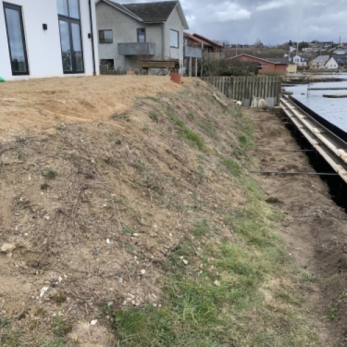 Udgravning og klargøring til støttemur langs skrænt ved kysten