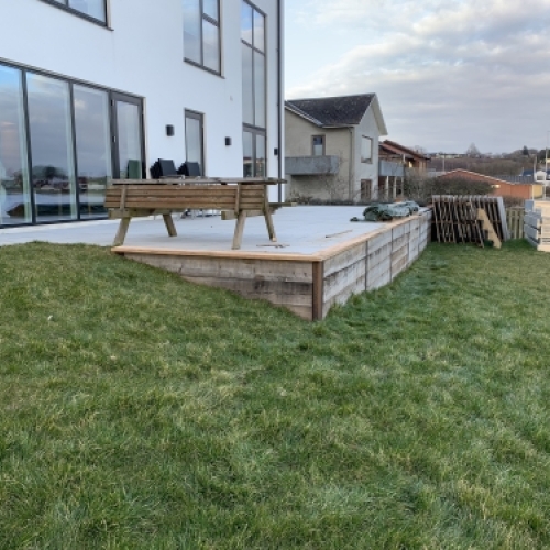 Etableret terrasse med kantopbygning ved ny bolig tæt på vand