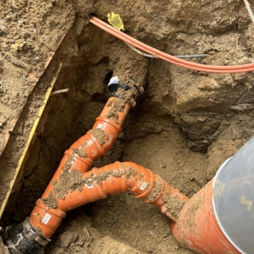 Kloakmester udfører kloakrensning og reparation af kloak tæt på husets fundament