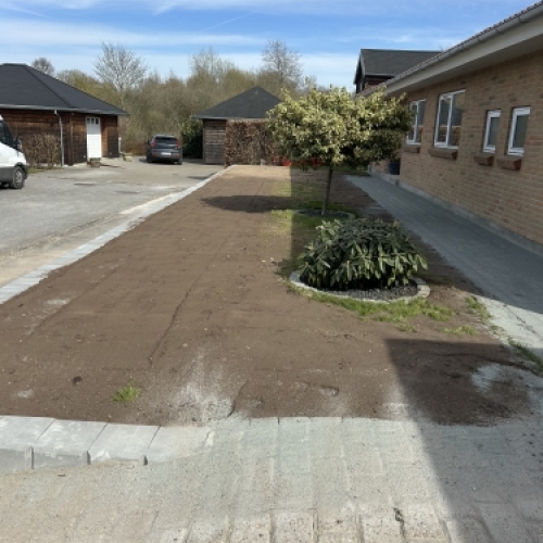 Planering og opfyld bag støttemur som del af færdiggørelse af terræn