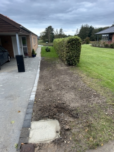 Kantafgrænsning langs hæk som forberedelse til belægning ved indkørsel