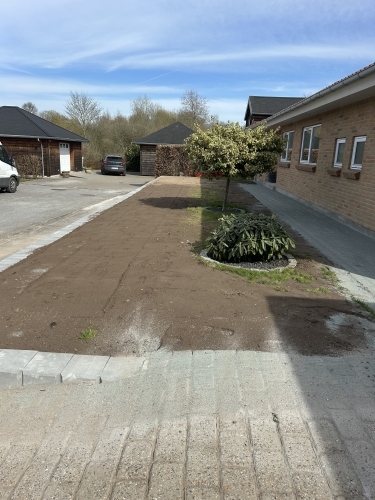 Planering og opfyld bag støttemur som del af færdiggørelse af terræn