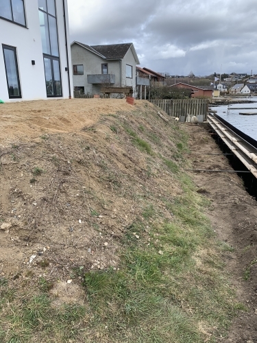 Udgravning og klargøring til støttemur langs skrænt ved kysten