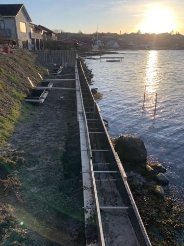 Kystnært anlægsprojekt med støbning forberedt langs vandet