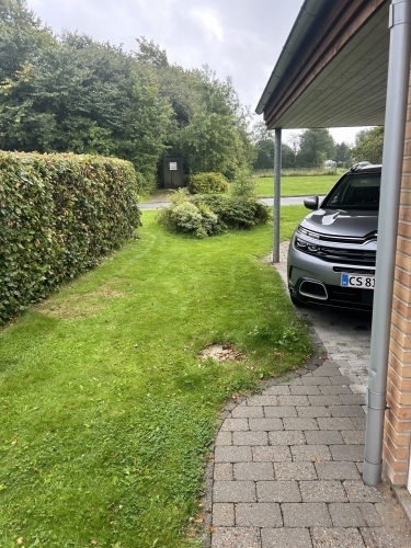 Udeareal efter belægningsarbejde med pæn overgang mellem fliser og græs