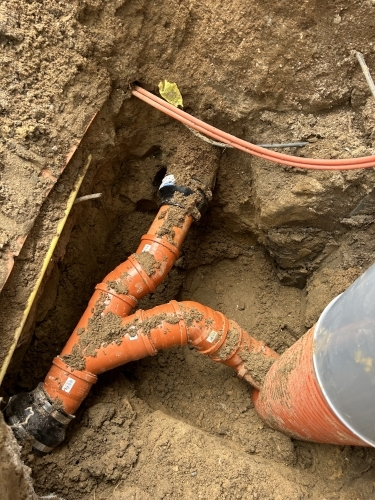 Kloakmester udfører kloakrensning og reparation af kloak tæt på husets fundament